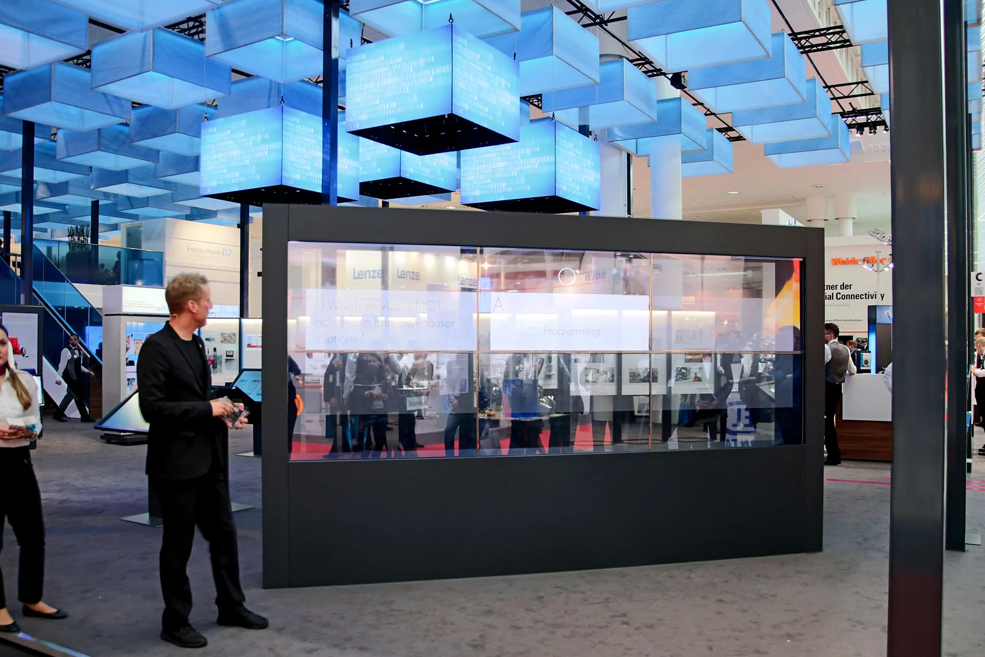 Großes Staunen unter den Messebesuchern erzeugt die optische Wirkung der transparenten OLED Powerwall in Verbindung mit dem Zusammenspiel aus produziertem Inhalt und der moderierten Live Präsentation. Über eine Animation schwappen je nach Thema bunte Flüssigkeiten in die Screens hinein oder wieder heraus. Dargestellte Texte werden teils überlagert und fließen mit der Flüssigkeit zusammen ab. 