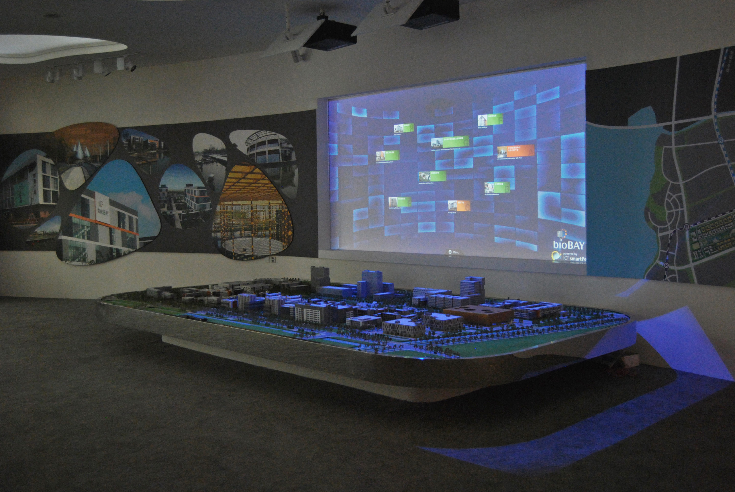 Another multimedia exhibit in the form of a scale terrain model serves visitors for interactive orientation on the grounds of the Suzhou Industrial Park. Using iPad control, individual buildings can be selected on a digital terrain plan and illuminated on the model. smartPerform visualizes the corresponding information to choose from on a projection surface positioned behind the model, which is played using suspended projectors.