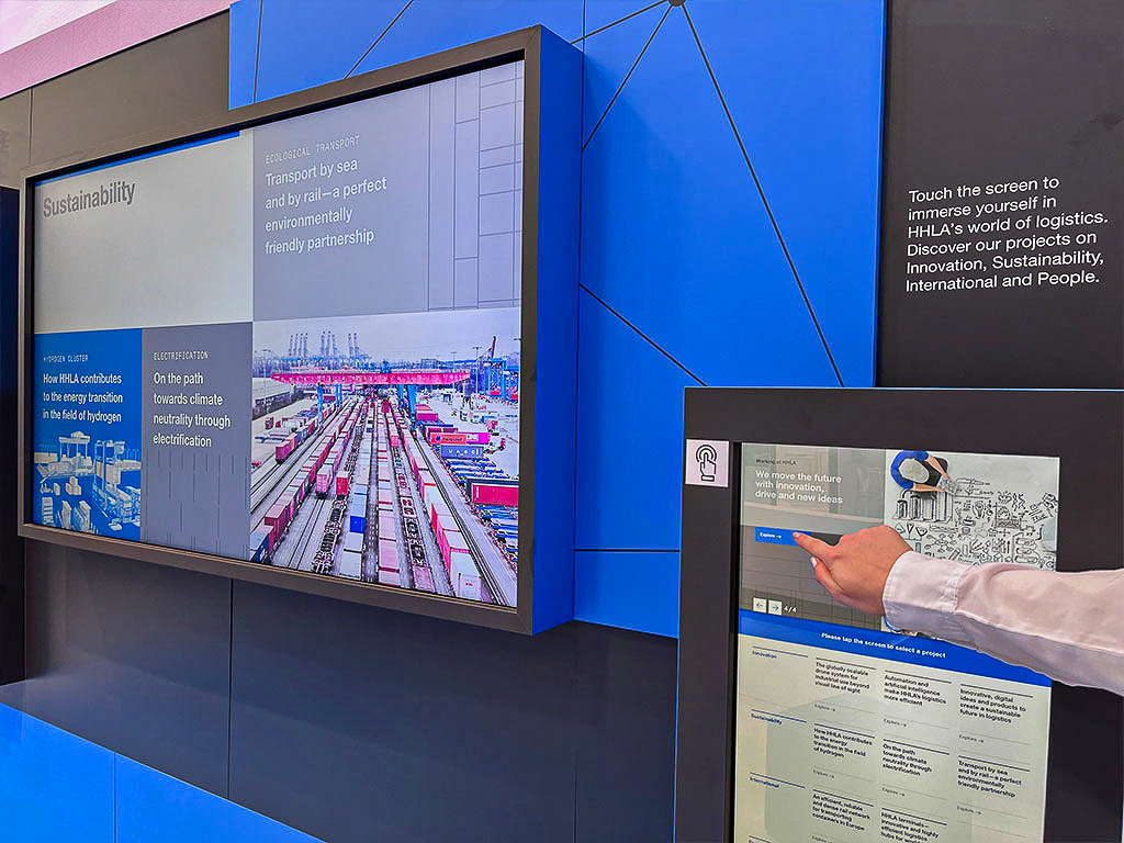 In the entrance area, a seating area invites visitors to linger. An impressive large screen in the form of an interactive multi-touch powerwall presents the Schuler brand and its products.